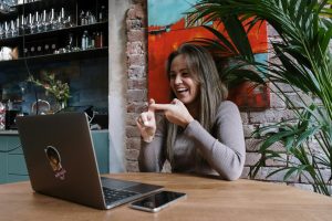 A woman communicates with someone online through sign language.